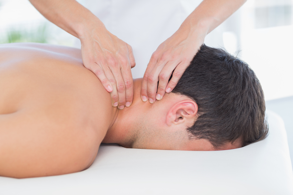A man rests face-down during a relaxing neck and shoulder massage.