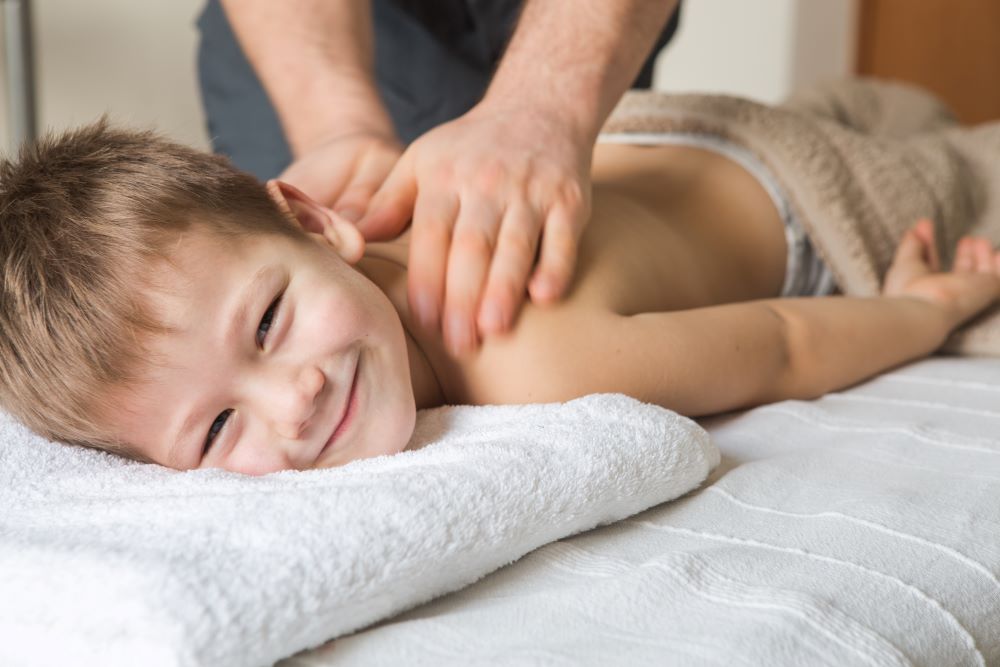 A young boy gets a relaxing back massage at a Bangkok spa.