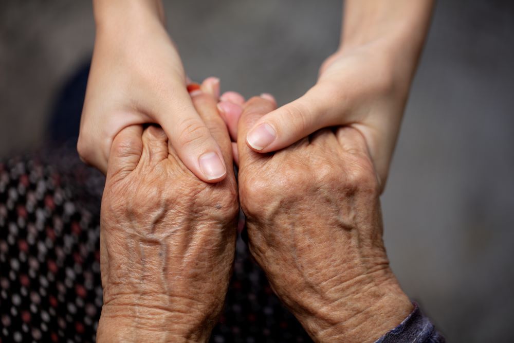  A gentle hand massage helps to ease arthritis soreness for an older woman.
