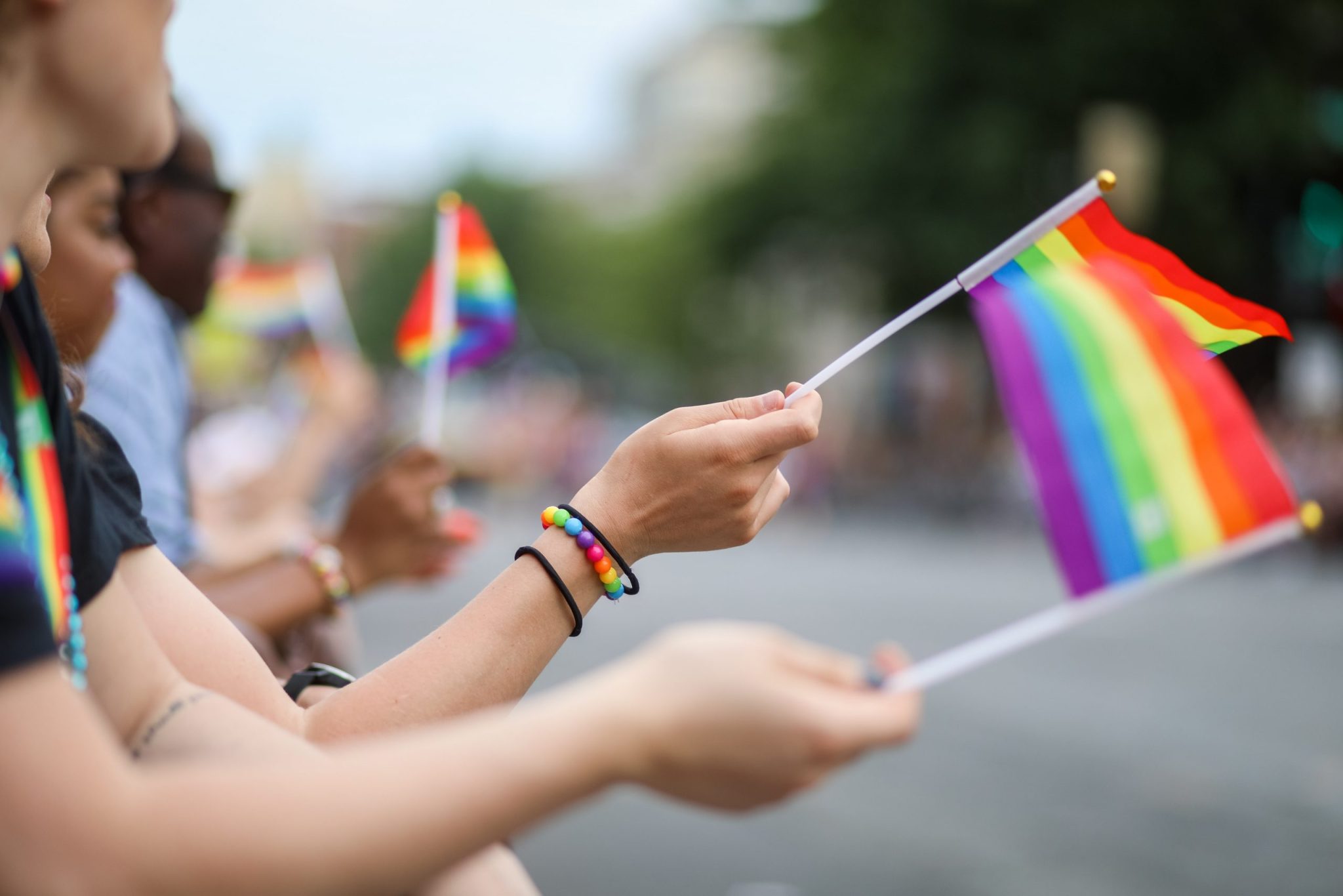 People wave rainbow flags at a Pride parade to celebrate LGBTQ+ rights.